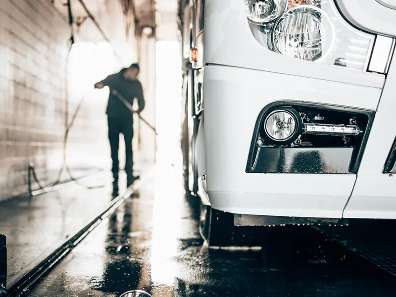 Un homme lave un camion dans le car wash américain.